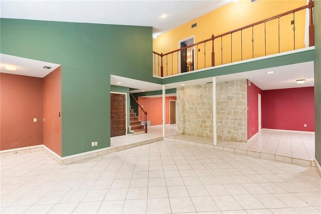 3100 S Casa Linda St, Mcallen, TX 78503 - unfurnished living room with stairs, a towering ceiling, and tile patterned floors