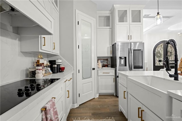 kitchen featuring exhaust hood, white cabinets, dark hardwood / wood-style floors, stainless steel fridge, and decorative light fixtures