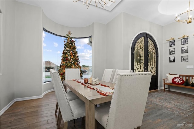 dining room featuring french doors, dark wood-type flooring, and an inviting chandelier