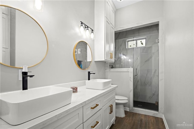 bathroom featuring vanity, wood-type flooring, an enclosed shower, and toilet