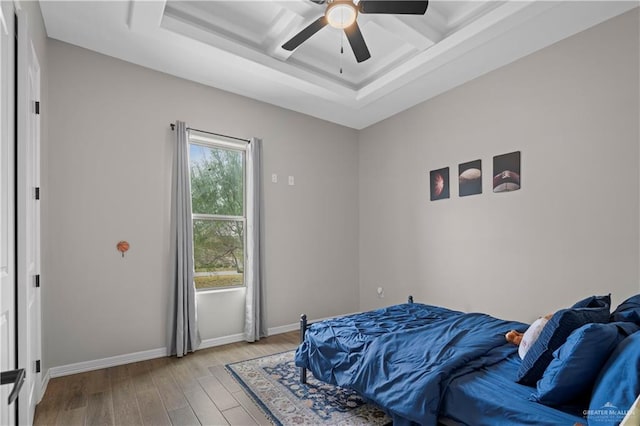 bedroom with ceiling fan, light wood-type flooring, and coffered ceiling