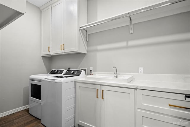 washroom with dark hardwood / wood-style flooring, washer and clothes dryer, cabinets, and sink