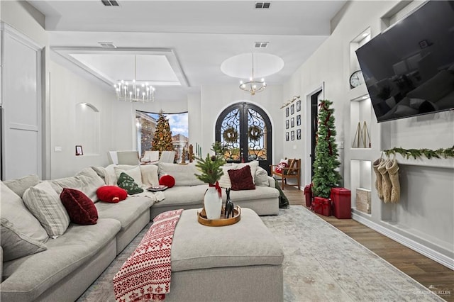 living room featuring french doors, hardwood / wood-style floors, and a notable chandelier