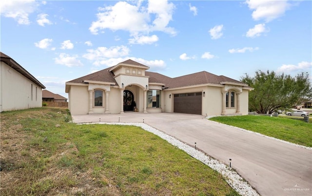 mediterranean / spanish-style house featuring a garage and a front lawn