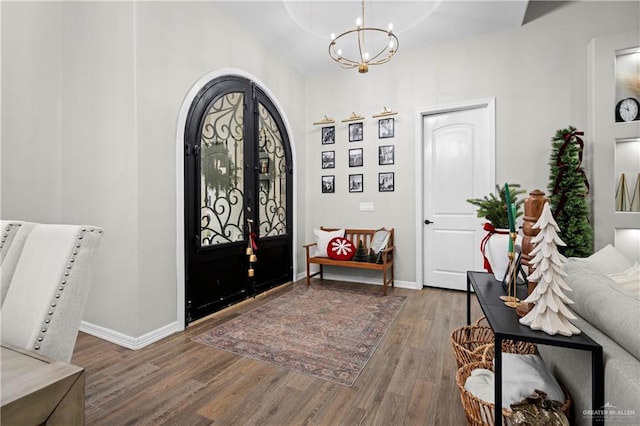 entrance foyer with french doors, a notable chandelier, and wood-type flooring