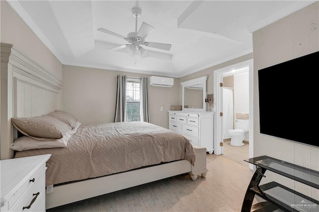 bedroom with a wall mounted AC, ensuite bath, ceiling fan, crown molding, and a raised ceiling