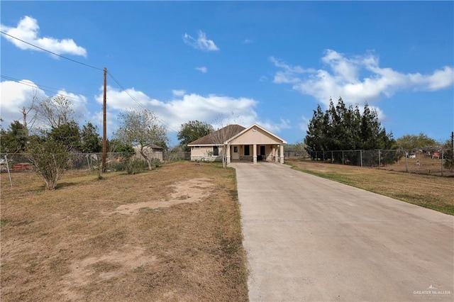 view of front facade with a front yard, fence, and driveway