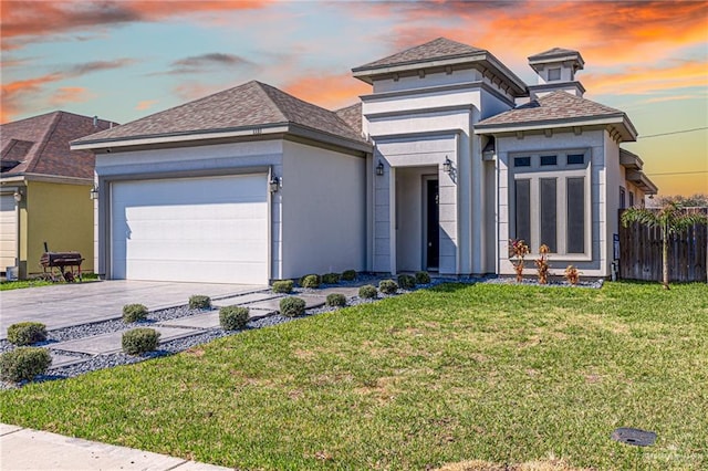 prairie-style house featuring a lawn and a garage