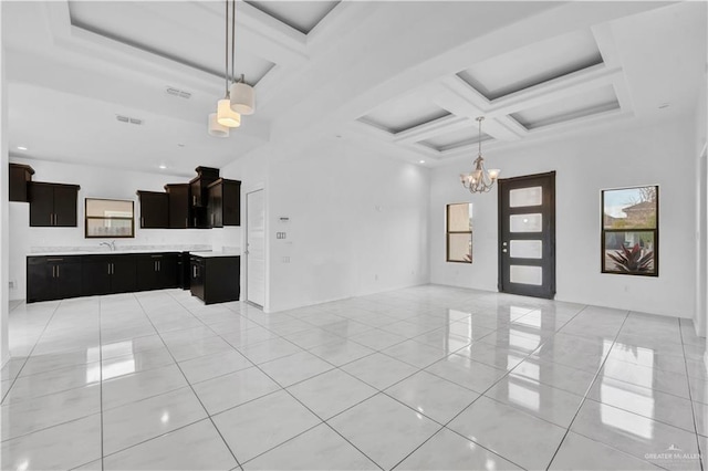 unfurnished living room with a high ceiling, a chandelier, coffered ceiling, beamed ceiling, and light tile patterned floors