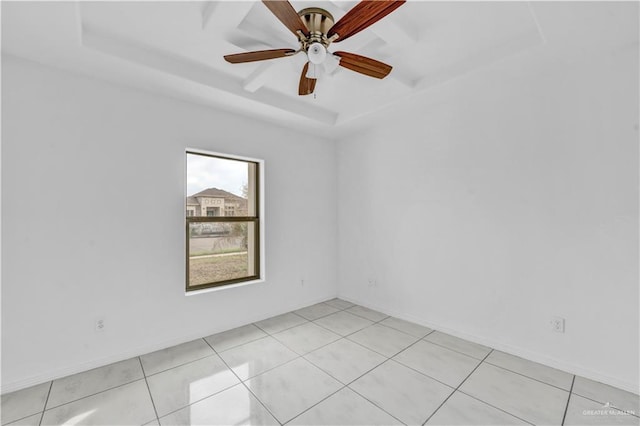 spare room with ceiling fan, light tile patterned floors, and a tray ceiling