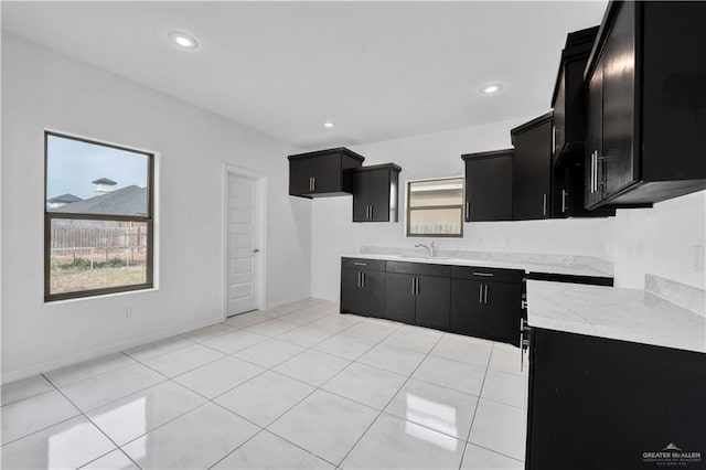 kitchen with sink, light tile patterned flooring, and a healthy amount of sunlight