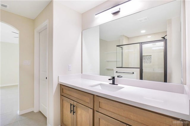 bathroom with vanity, a shower with shower door, and tile patterned floors