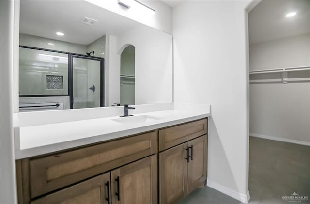 bathroom with a shower with door and vanity