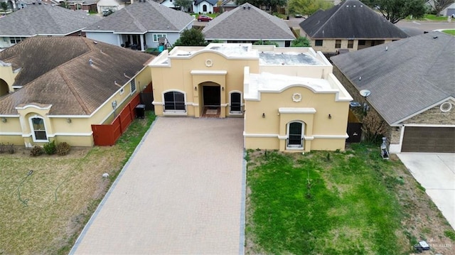 view of front of property with a front yard, a residential view, decorative driveway, and stucco siding