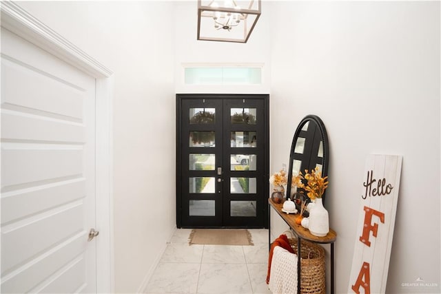 foyer featuring a chandelier and french doors