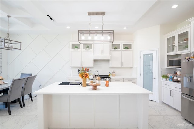 kitchen with appliances with stainless steel finishes, sink, a center island with sink, white cabinets, and hanging light fixtures