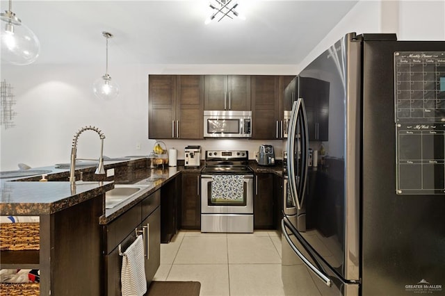 813 Travis St Unit 203, Mission, TX 78572 - kitchen with stainless steel appliances, a peninsula, dark brown cabinets, light tile patterned flooring, and hanging light fixtures