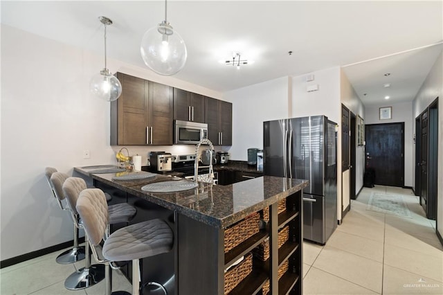813 Travis St Unit 203, Mission, TX 78572 - kitchen with appliances with stainless steel finishes, dark brown cabinets, light tile patterned floors, a breakfast bar area, and hanging light fixtures