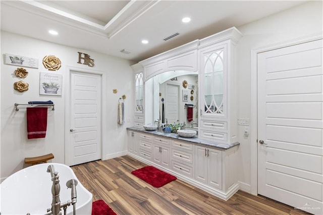 bathroom featuring hardwood / wood-style floors, vanity, and a tub to relax in