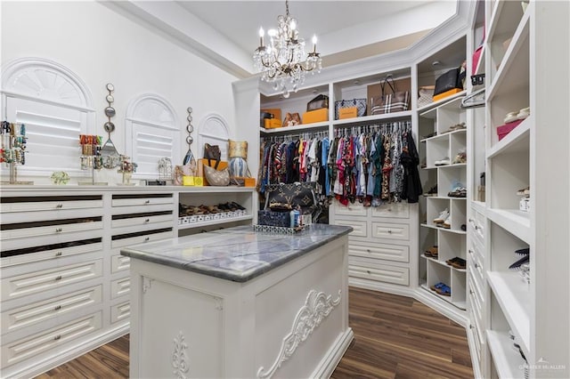 walk in closet with dark hardwood / wood-style flooring and a notable chandelier