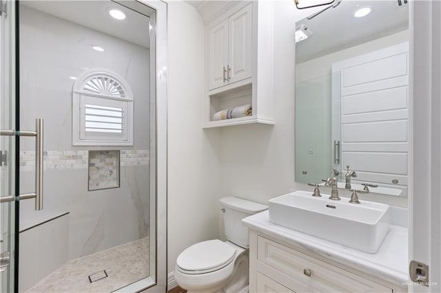 bathroom with vanity, a shower with shower door, and toilet