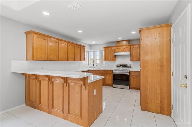 kitchen featuring a breakfast bar, sink, electric range, light tile patterned flooring, and kitchen peninsula