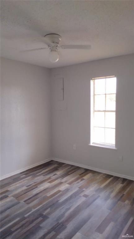 spare room with dark hardwood / wood-style floors and ceiling fan