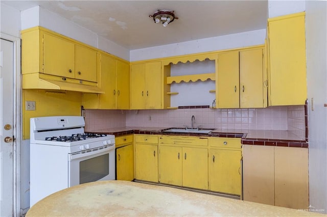 kitchen with tile countertops, tasteful backsplash, white gas stove, and sink