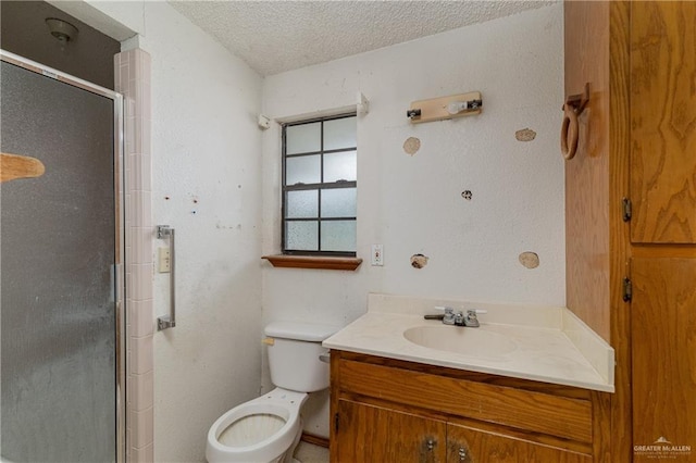 bathroom featuring vanity, an enclosed shower, a textured ceiling, and toilet