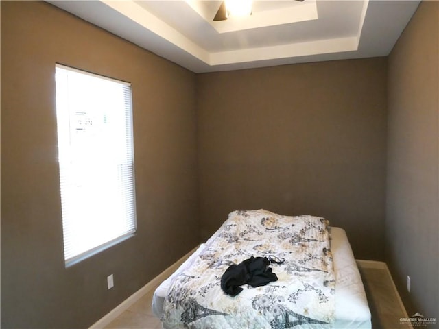 bedroom featuring a raised ceiling and ceiling fan