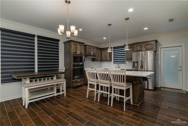 kitchen with a center island, light countertops, decorative backsplash, appliances with stainless steel finishes, and dark brown cabinetry