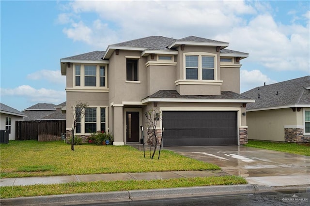 prairie-style home featuring a garage, fence, driveway, stucco siding, and a front lawn