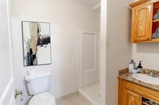 bathroom with walk in shower, vanity, tile patterned flooring, and toilet