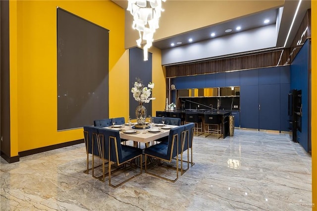 4704 Estancia Pkwy, Mcallen, TX 78504 - dining room with light marble finish floors, a towering ceiling, and a chandelier