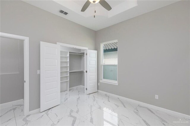 3205 Brentwood St, Edinburg, TX 78539 - unfurnished bedroom featuring baseboards, marble look tile flooring, a closet, ceiling fan, and a tray ceiling