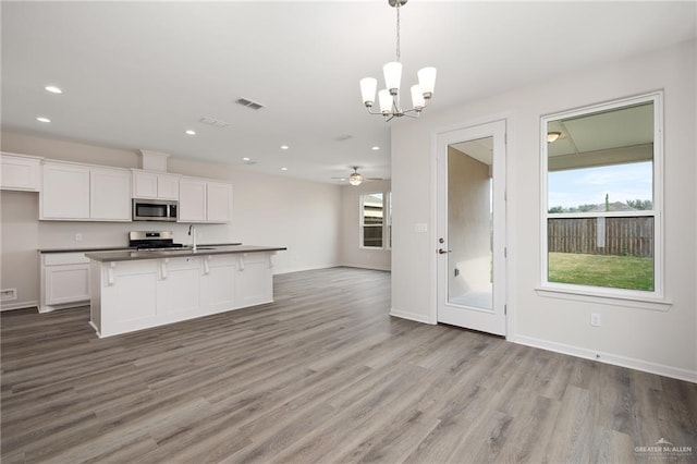 kitchen with visible vents, dark countertops, appliances with stainless steel finishes, light wood-type flooring, and open floor plan
