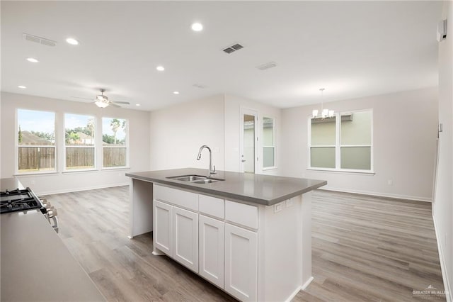 kitchen with a sink, ceiling fan with notable chandelier, open floor plan, light wood-style floors, and recessed lighting