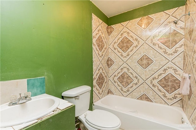 full bathroom featuring vanity, tiled shower / bath combo, tile walls, and toilet