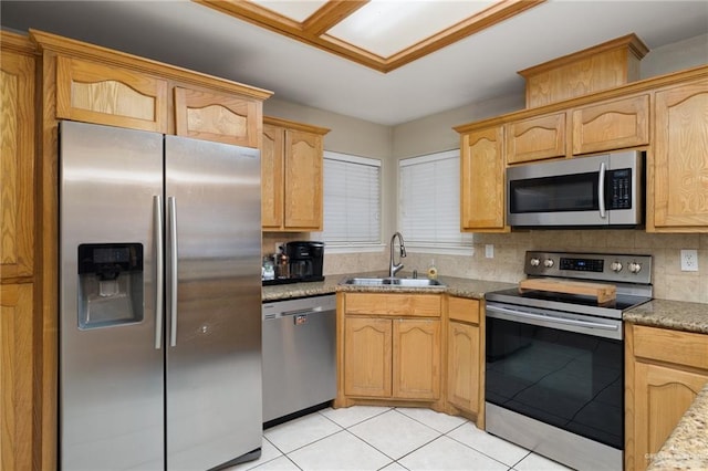 kitchen featuring sink, light brown cabinets, light stone counters, decorative backsplash, and appliances with stainless steel finishes