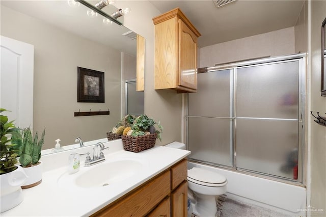 full bathroom with vanity, toilet, and bath / shower combo with glass door