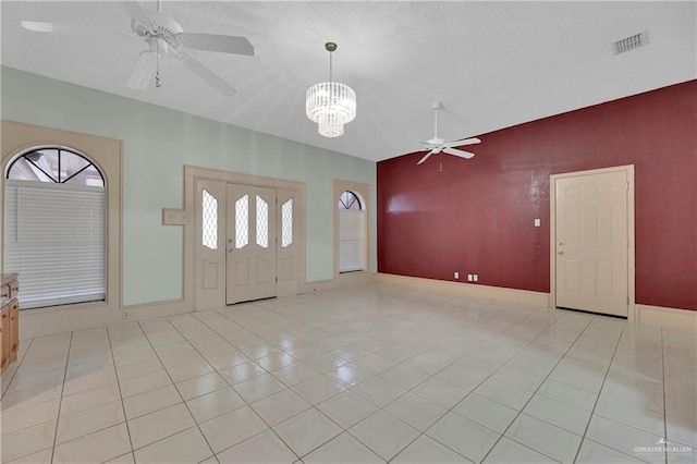 foyer featuring light tile patterned floors, a textured ceiling, and a chandelier