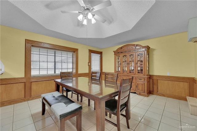 dining area featuring ceiling fan, light tile patterned floors, and a textured ceiling