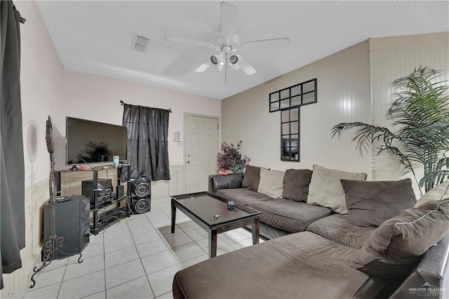 living room featuring ceiling fan, light tile patterned floors, and a textured ceiling