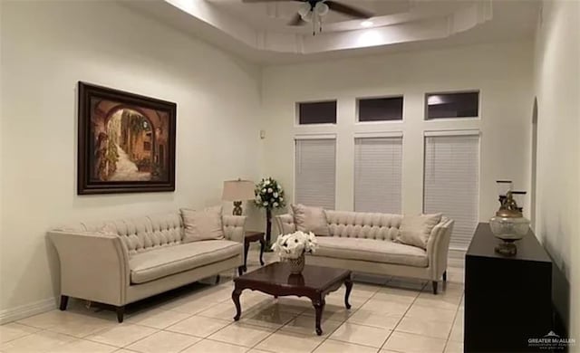 interior space with light tile patterned floors, a raised ceiling, ceiling fan, and a high ceiling