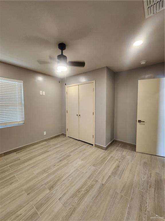607 N Padre Ave, Weslaco, TX 78596 - unfurnished bedroom featuring light wood-style floors, a closet, and a ceiling fan