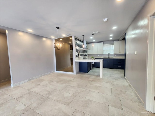 607 N Padre Ave, Weslaco, TX 78596 - kitchen with light countertops, recessed lighting, hanging light fixtures, a chandelier, and wall chimney exhaust hood