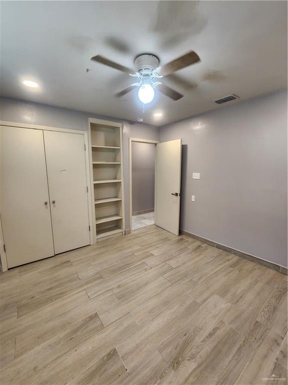 607 N Padre Ave, Weslaco, TX 78596 - unfurnished bedroom featuring light wood finished floors and a ceiling fan