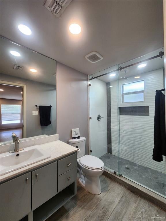 607 N Padre Ave, Weslaco, TX 78596 - bathroom with wood finished floors, vanity, a shower stall, plenty of natural light, and recessed lighting
