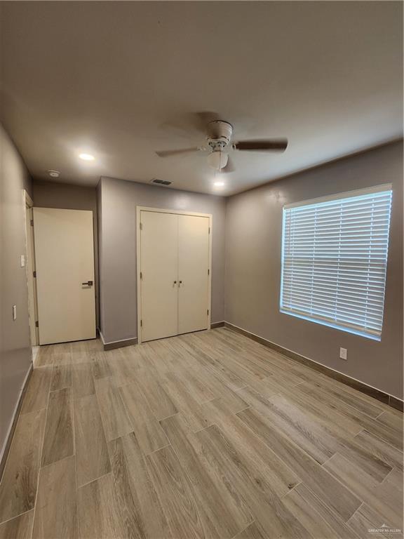 607 N Padre Ave, Weslaco, TX 78596 - unfurnished bedroom featuring light wood-type flooring, a ceiling fan, a closet, and recessed lighting