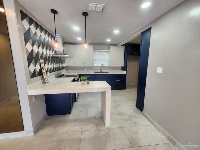 607 N Padre Ave, Weslaco, TX 78596 - kitchen featuring island exhaust hood, light countertops, a peninsula, recessed lighting, and white cabinetry